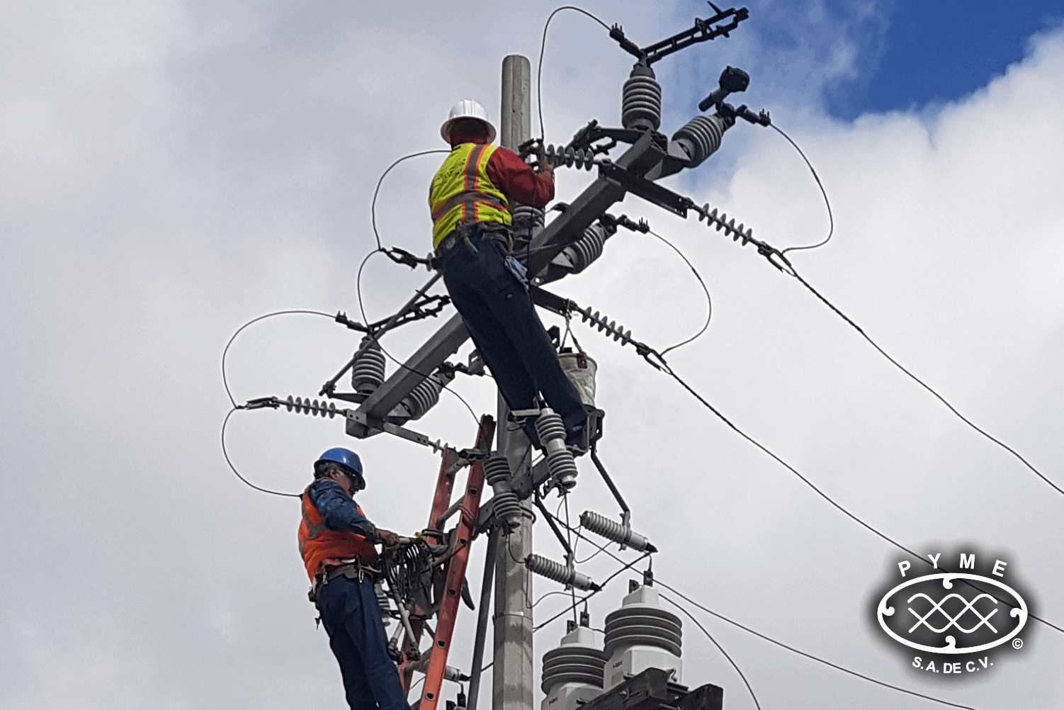 Trabajadores en poste de línea de transmisión eléctrica
